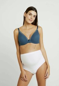 Teal modrca spodnjega perila z mehkobnim, teksturiranim materialom, nastavljivimi naramnicami in čipkastimi detajli. V kombinaciji z belim visokim spodnjim perilom.