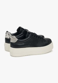 Zwarte leren sneakers met een gestructureerde grijze accent op de hiel, voorzien van ronde veters en een dikke witte zool. Het ontwerp bevat perforatiedetails.