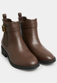 Botas de tobillo de imitación de cuero marrón con un diseño elegante, acentos de hardware dorado, cierre de cremallera y un bajo tacón tipo bloque. Acabado suave y brillante.