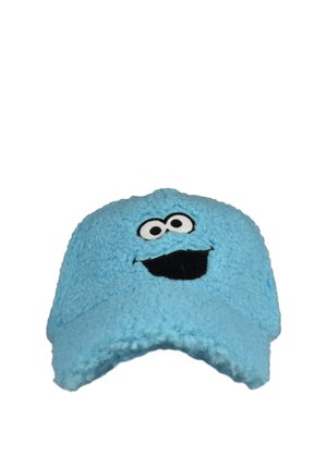 Light blue fuzzy cap with a smiling cartoon face featuring large eyes and a wide black mouth on the front panel.