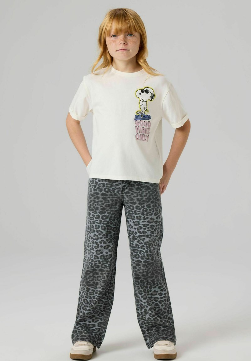 Hvit bomulls-t-skjorte med Snoopy-grafikk i svart og gult. Kombinert med grått, vidt leopardm�ønstrede bukser med høy midje.