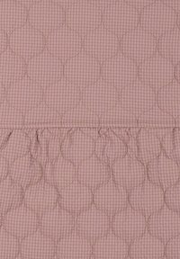 Tela acolchada rosa con un patrón geométrico que presenta formas circulares, contorneadas con costuras sutiles y una superficie texturizada.