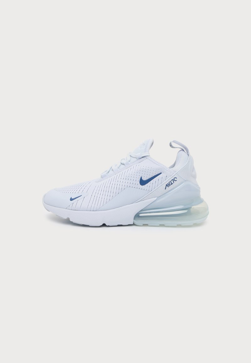 Λευκό αθλητικό παπούτσι Nike Air Max 270 με λογότυπα Swoosh σε ναυτικό μπλε, επάνω μέρος από δίχτυ και μεγάλη διάφανη σόλα με αερόσακο, προβληματισμένο από το πλάι.