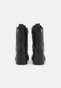 Czarne skórzane botki za kostkę z grubym obcasem, z zamkiem błyskawicznym z boku oraz elastycznymi panelami z wytłoczonym logo z tyłu.