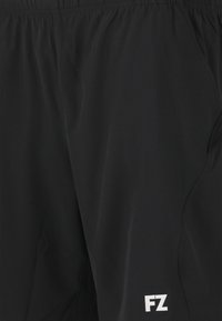 Svarta sportshorts i lättviktsmaterial; har resårmidja och sidfickor; liten vit logo på nedre vänstra benet.