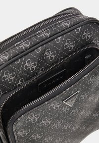 Borsa in pelle nera con motivo logo, chiusura con zip e dettagli metallici. Esterno texture con scomparti multipli all'interno.