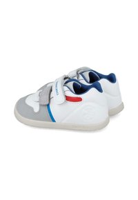 Zapatillas blancas y grises con detalles en azul y rojo, que cuentan con una correa de velcro, interior acolchado y suela de goma texturizada.