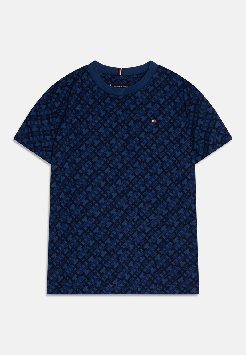 Camiseta de manga corta azul marino con un patrón geométrico en toda la superficie y un pequeño logo rojo, blanco y azul en el pecho izquierdo.