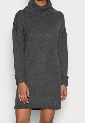 Dark gray, long-sleeve knit sweater dress with a wide turtleneck and cuffed sleeves worn by a person with visible hands and legs.