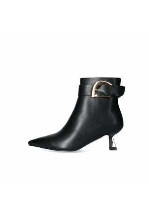 Stivaletto nero in pelle con punta affusolata, dettaglio con fibbia dorata sul cinturino e tacco scultoreo e affusolato. Texture liscia in tutto il prodotto.