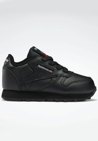 Svart lädersneaker med en strukturerad yta, rund tå, snörningsdesign och Reebok-logotyp. Har en gummisula med greppmönster.