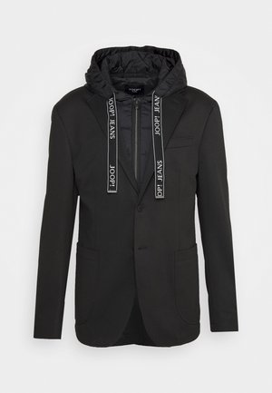 Sort blazer med fastsyet quiltet hætte, lynlås foran og snore med mærket "JOOP! JEANS," der har to forlommer og en brystlomme.