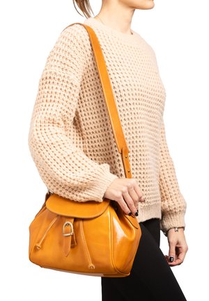 Sac à main en cuir jaune avec une forme arrondie, un rabat supérieur et une bandoulière réglable. Présente une boucle et des détails de couture.