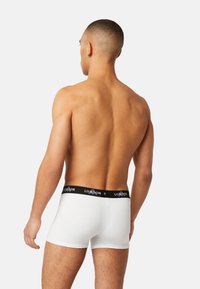 White cotton boxer briefs with a black elastic waistband featuring "LONDON" in white, shown from the back on a bare torso.