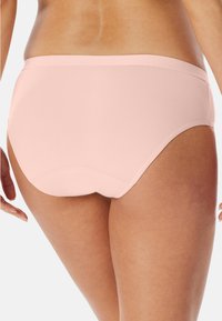 Helles rosa, nahtloses Unterwäsche mit hochgezogenem Design. Glatte Textur und geschwungene Kanten bieten volle Abdeckung und eine enge Passform.