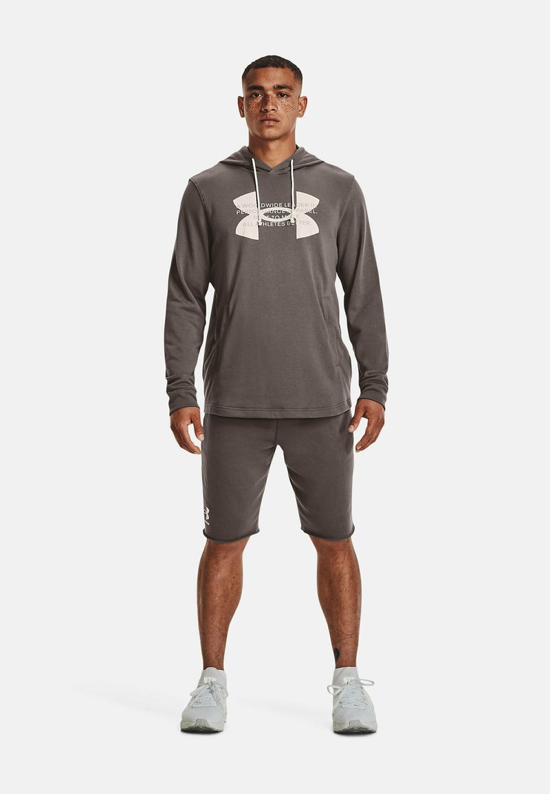 Grijze hoodie met een groot wit logo, gecombineerd met bijpassende grijze shorts. Het materiaal lijkt zacht; heeft lange mouwen en een voorzak.