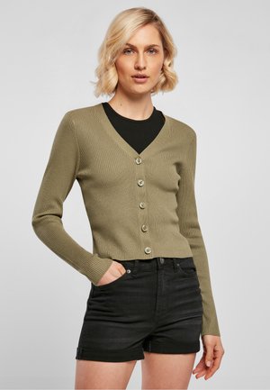 Olivenfarget ribbestrikket cardigan med V-hals, lange ermer og seks knappelukking, sammen med svarte denimshorts.