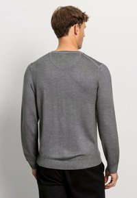 Grauer Strickpullover mit Rundhalsausschnitt und langen Ärmeln, mit gerippten Bündchen und Saum, der eine glatte Textur und minimale Nähdetails auf der Rückseite aufweist.