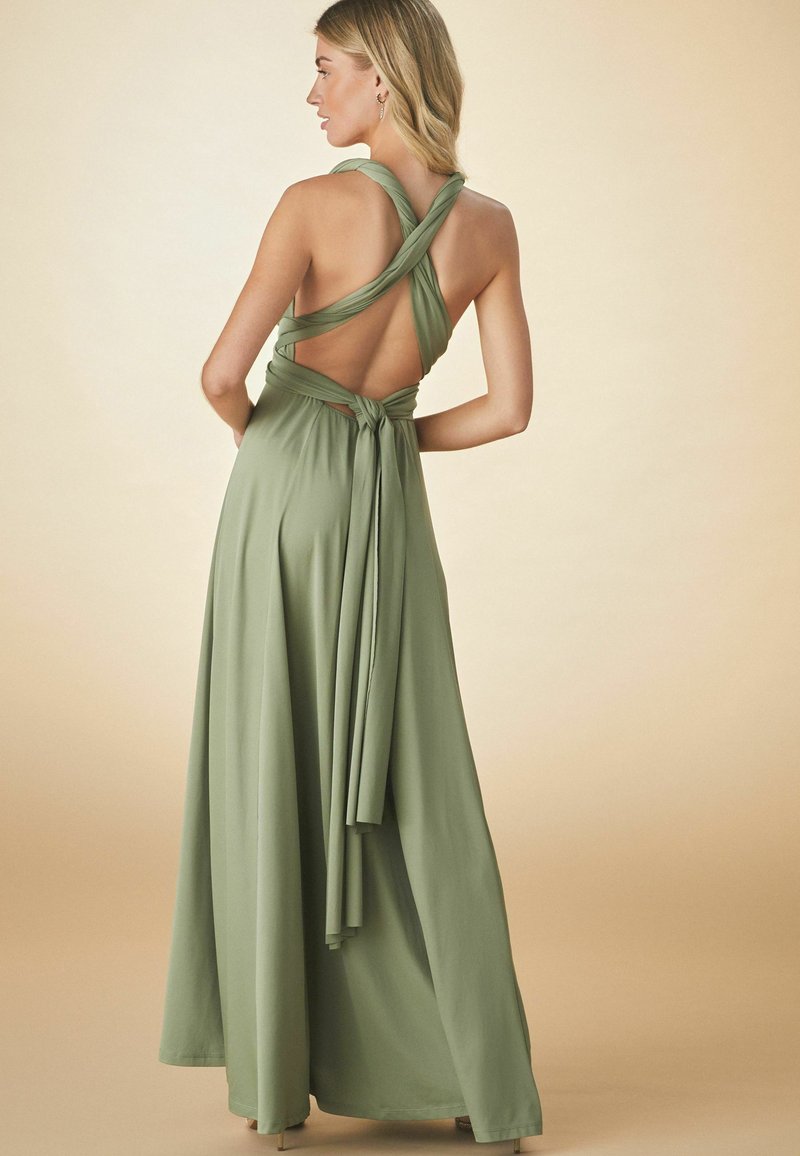 Langes, olivengrünes Kleid mit rückenlosem Design, ausgestattet mit überkreuzten Trägern und einem gebundenen Taillenband. Der glatte, leichte Stoff fällt elegant.
