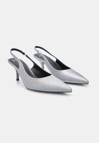 Chaussures à talons hauts argentées à bride arrière avec un bout pointu et un matériau texturé. Présente une fine bride de cheville et un design élancé.