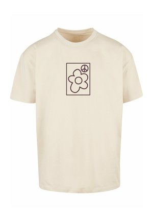 cremefarbenes T-Shirt aus weichem Material, das auf der Vorderseite ein braunes Blumenmotiv und ein Friedenssymbol in einem rechteckigen Rahmen zeigt.
