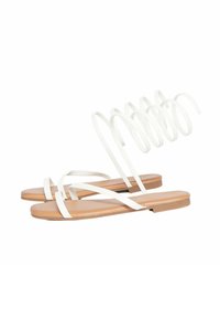 Sandali bianchi con fascette e suola piatta color nocciola. Caratteristiche includono sottili fasce a incrocio e un dettaglio avvolto sul tallone. Texture liscia.