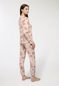Set di pigiama rosa con maniche lunghe e pantaloni decorati con un motivo di orsetti. Realizzato in tessuto morbido, offre una vestibilità comoda e polsini elastici.
