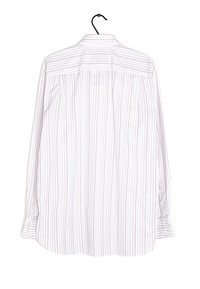 Vit långärmad skjorta med fina röda horisontella ränder, knappade manschetter, skräddarsydd krage och plisseringar längs ryggen. Hänger på en svart krok.