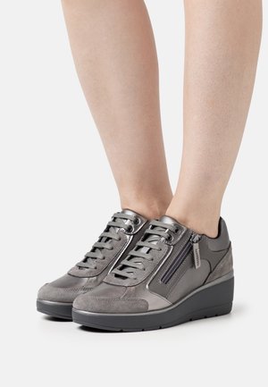 Grå mocka och lädersneakers med en tjock kilklackssula, med snören, en sidodragkedja och en slät yta.