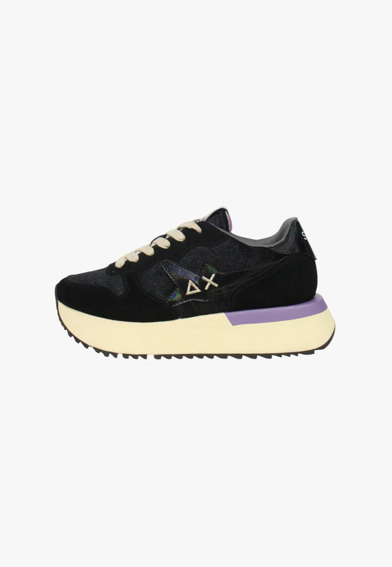 Sneaker nera con una combinazione di materiali testurizzati, lacci crema, accenti viola sulla suola e un dettagli shiny nero sul tallone.