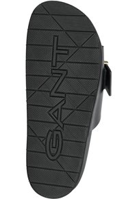 Černá gumová podrážka sandálů s texturovaným vzorem. Obsahuje výrazné logo GANT, hladké okraje a robustní podpatek pro stabilitu.