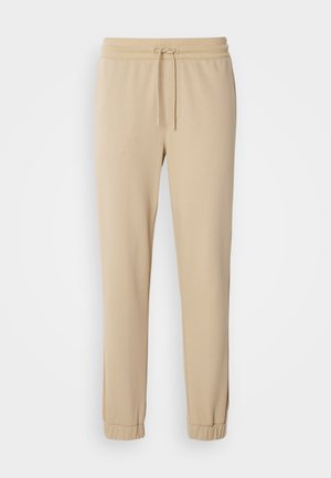 Beige jogger pants made of soft fabric, featuring a drawstring waist, tapered legs, and elastic cuffs. Smooth texture with no visible patterns.