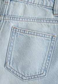 Jasnoniebieski materiał dżinsowy z pojedynczą tylną kieszenią z obszytymi krawędziami i wyblakłą fakturą, typową dla casualowych jeansów.