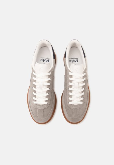 Pair of light gray suede sneakers with white laces and brown rubber soles, viewed from above on a white background.