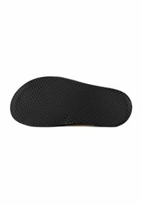 Semelle de chaussure en caoutchouc noir avec un motif texturé en forme d’écailles et une petite marque circulaire de taille près du centre sur fond blanc.