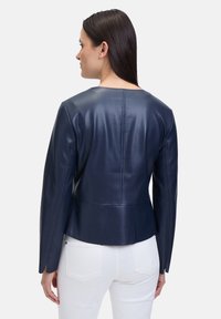 Navy-blaues Lederjacke mit tailliertem Schnitt, langen Ärmeln und geradem Saum. Verfügt über ein sauberes Design und subtile Nahtdetails auf der Rückseite.