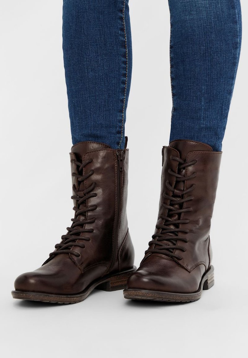 Botas de cuero marrón hasta el tobillo con diseño de cordones y cremallera lateral, que cuentan con puntera redondeada y suela robusta para mayor durabilidad.