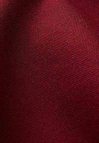 Tissu texturé d'une couleur bordeaux profonde, présentant un motif en damier et une finition douce. Convient à diverses applications textiles.