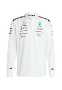 White long-sleeve polo shirt with a collar, featuring black stripes, multiple sponsor logos on the front and sleeves, and Adidas branding.