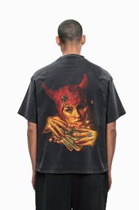 Black oversized t-shirt featuring a colorful graphic design on the back, depicting a figure with red horns and hands holding money.