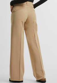 Beige wijde benen broeken met een gladde textuur, hoge taille en zijzakken. De stof heeft een op maat gemaakte uitstraling, ideaal voor formele kleding.