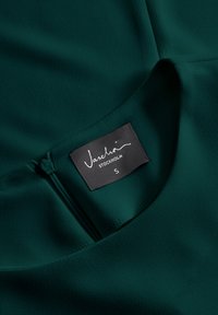 Südametöö roheline pluus pehmest materjalist, ümmarguse kaelusega, näidatud lukuga detail ja hooldusetiketil on kirjas "Vasch." ning suurus S.