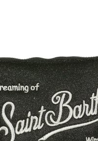 Sacca in tessuto nero lucido e scintillante con testo ricamato bianco che recita "Sognando Saint Barth." Texture liscia con bordo superiore ondulato.