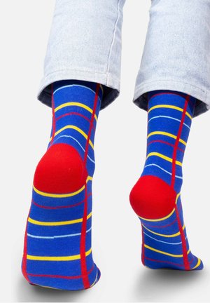 Niebieskie skarpetki z czerwonymi akcentami, z żółtymi i białymi poziomymi paskami oraz wzmocnionymi czerwonymi sekcjami pięty i palców.