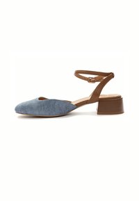 Kengät slingback denim-materiaalista, pyöreällä kärjellä, ruskealla nilkkaremmillä ja matalalla lohkaremmillä, jotka ovat vaaleansinisiä ja teksturoidun pinnan omaavia.