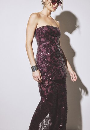 Bezplecu purpursarkans sāks ar pieguļošu augšdaļu un slāņveida pepluma apakšdaļu, kurai ir caurspīdīga daļa apakšā un ziedu raksti.