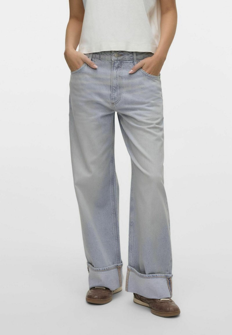 Jean large bleu clair avec une finition délavée, fermeture à bouton et ourlets retroussés. Fabriqué en tissu en denim avec des poches avant.