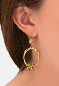 Boucles d'oreilles en or en forme de cercle, ornées de perles colorées en orange, jaune et turquoise. Détail texturé sur la tige.