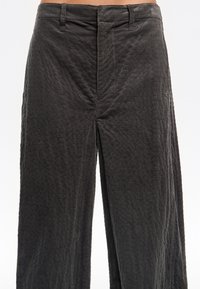 Pantalones de pana de pierna ancha en gris oscuro, con textura de canalé vertical, frontales planos y bolsillos laterales. Corte estructurado y relajado.