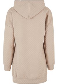 Sweat à capuche beige matelassé avec une capuche, des épaules tombantes et des manches longues. Le tissu présente un motif en losange et des poignets et un ourlet élastiques.